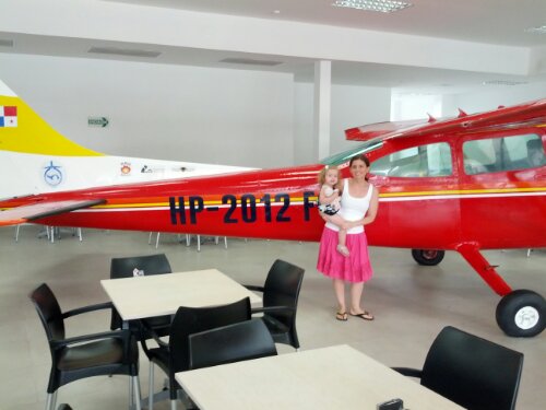 Misse and Frankie in front of a bi-plane inside the airport